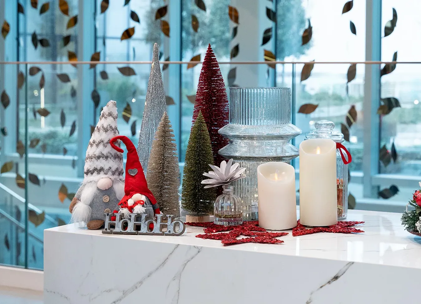 Элегантная рождественская композиция на мраморной поверхности коллекции Elements Lux с свечами и праздничными украшениями.