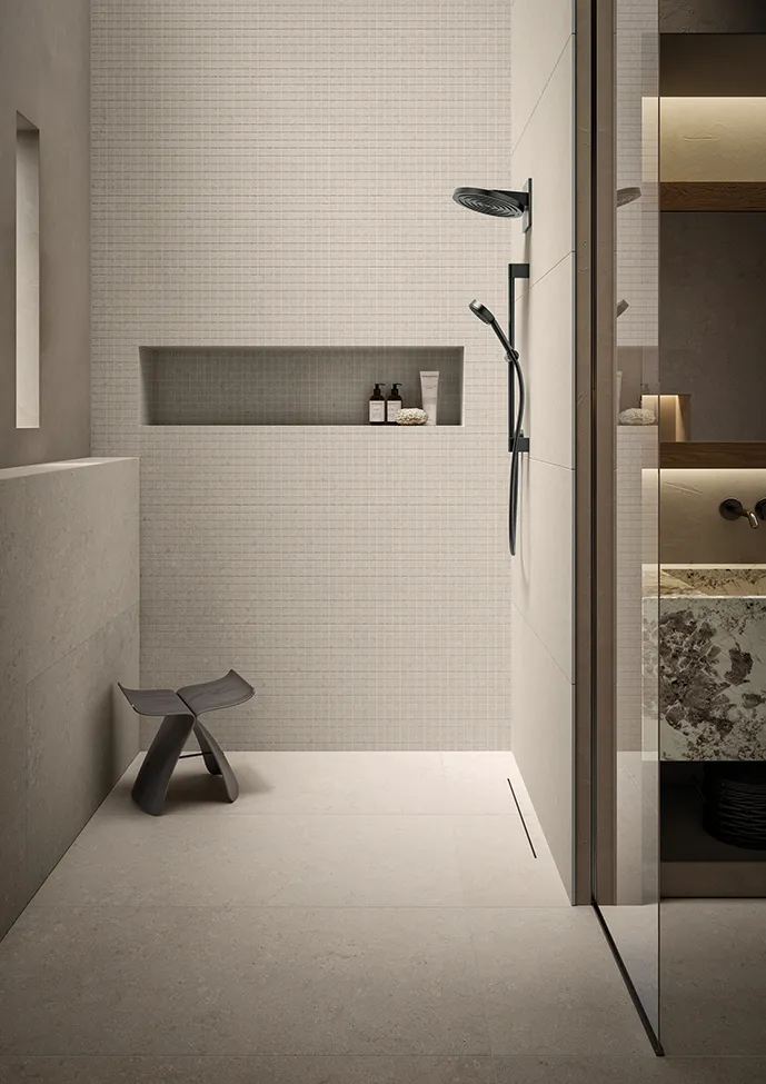 Минималистичная элегантная ванная комната с душевым поддоном из керамогранита коллекции Heritage цвета Pearl, окружённая мозаичной плиткой.