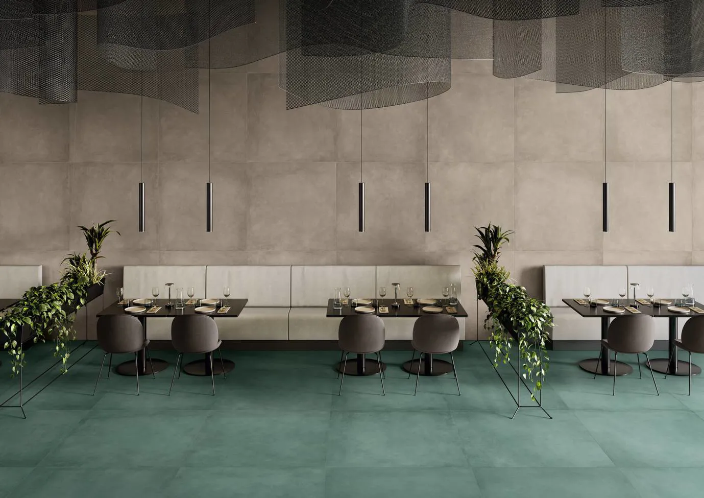 Ristorante sofisticato con pavimento in grès porcellanato effetto metallo della collezione Plate in tonalità Oxyde, arredamento moderno e lampade pendenti, impreziosito da piante verdi.
