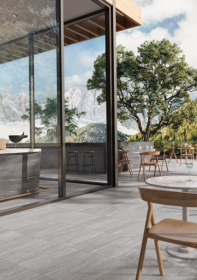 Mountain rooftop with gray porcelain stoneware tiles, modern furniture, and a breathtaking mountain view.
