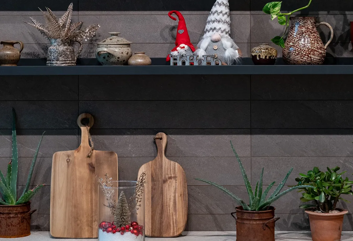 Cucina accogliente con piastrelle effetto pietra della collezione Brystone, decorazioni natalizie tradizionali e accessori in legno naturale.