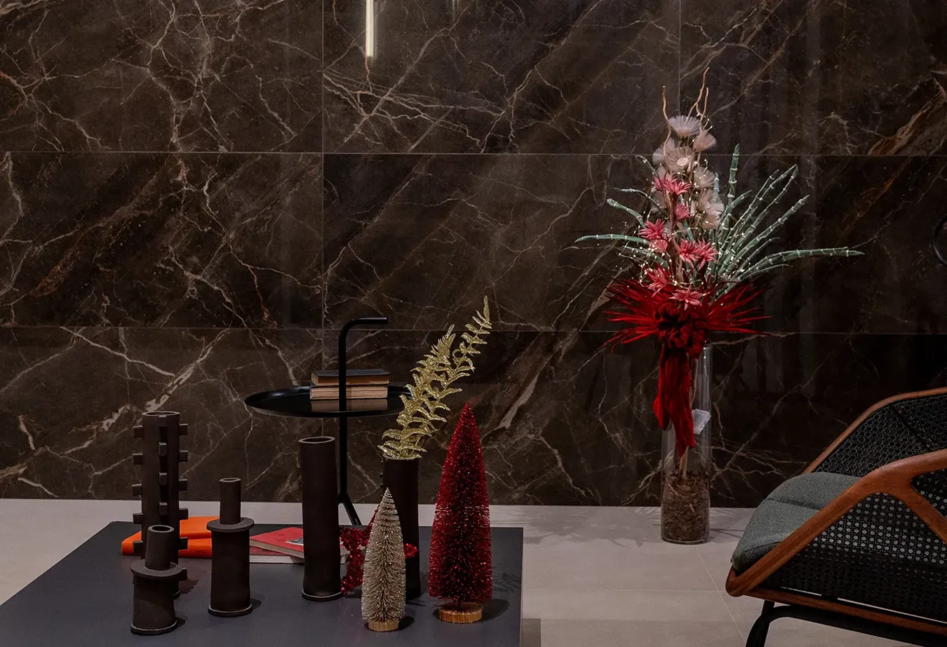 Elegant interior with dark marble walls and festive Christmas decorations on a modern side table.