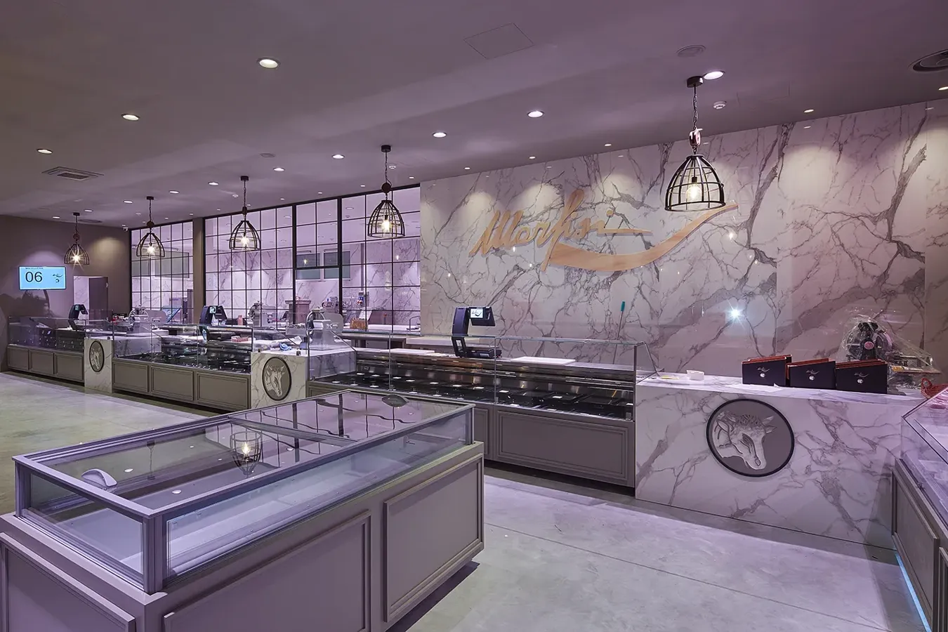 Luxurious gelato shop interior with walls and counter in Calacatta white marble effect stoneware.