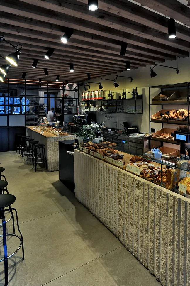 Design moderno di caffetteria con pavimento in gres porcellanato effetto pietra beige.