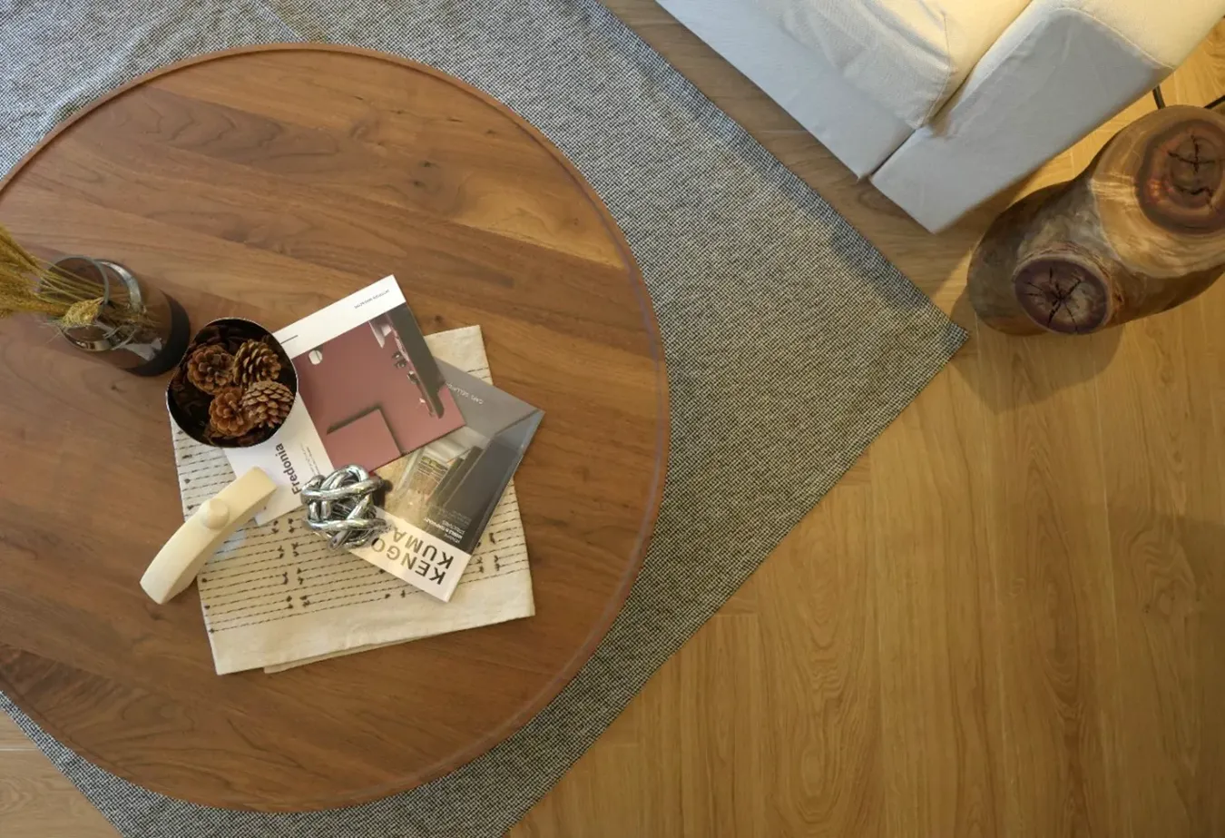 Плитка из керамогранита под светлое дерево с журнальным столиком и белым диваном в уютной современной гостиной.