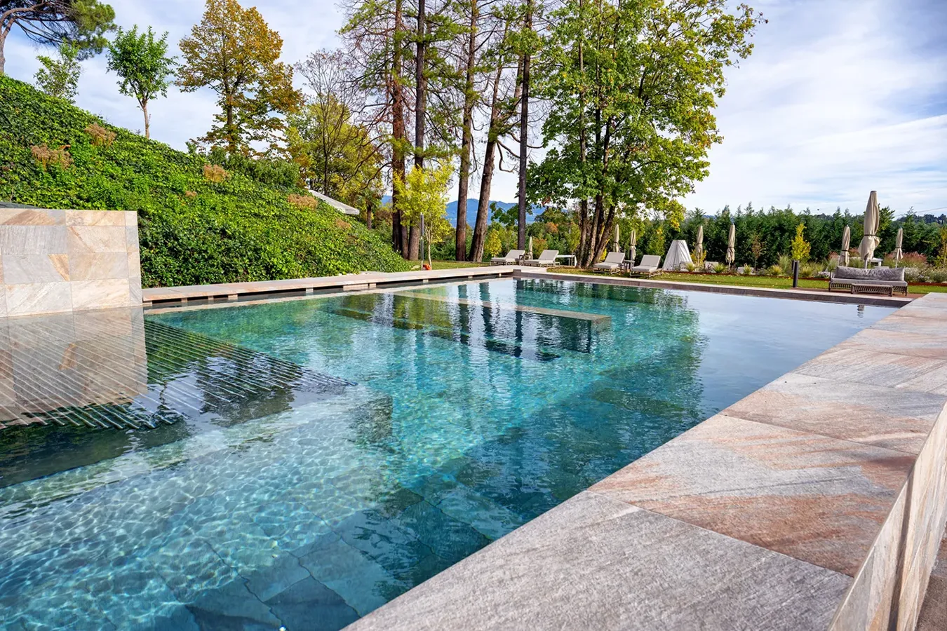 Schwimmbad mit rutschfesten Fliesen in Steinoptik Limes Quartz Multicolor im Außenbereich.