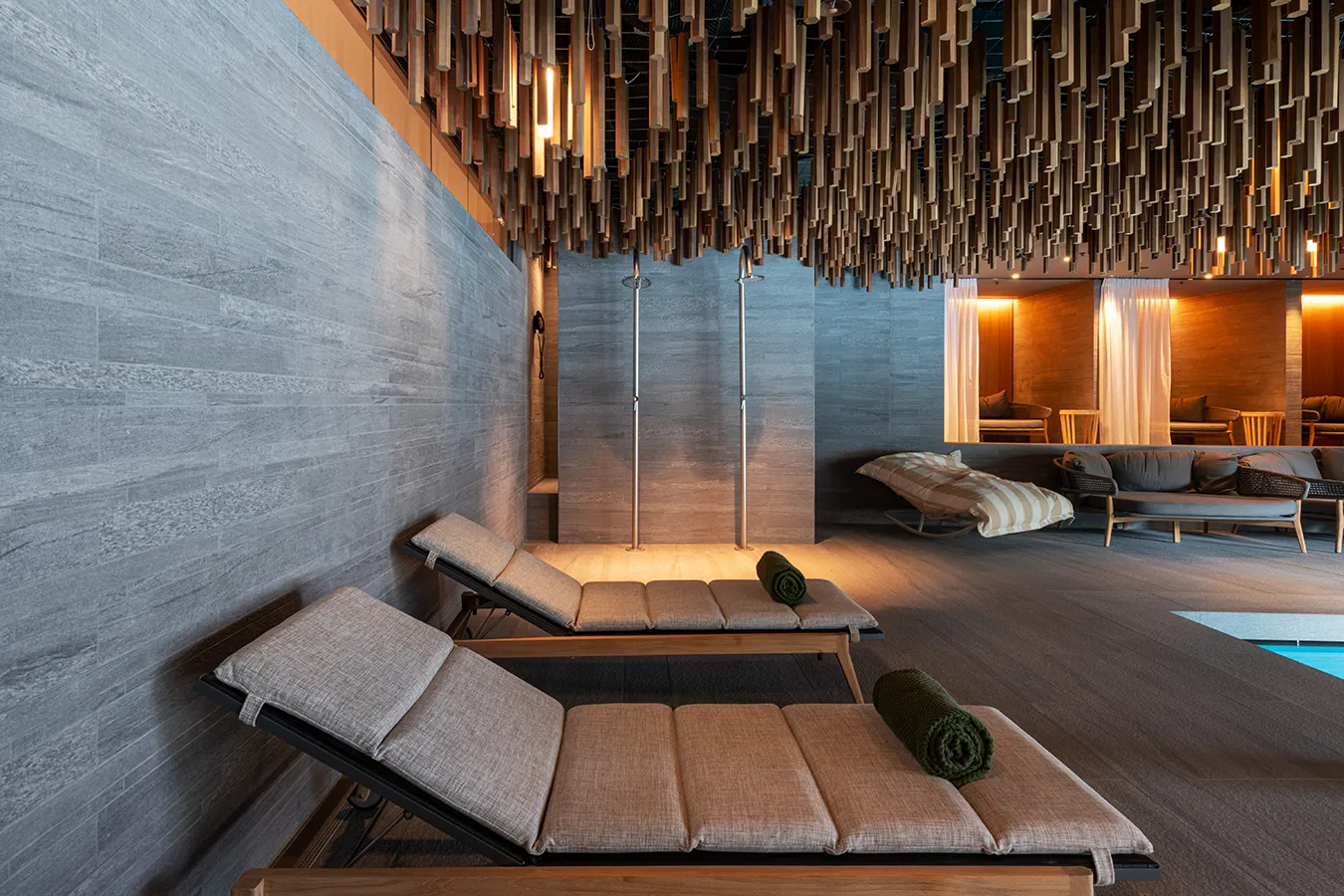 Relaxation area at Six Senses Crans-Montana featuring porcelain stoneware cladding from the Percorsi Smart collection, contemporary design, and textile loungers for pure comfort.