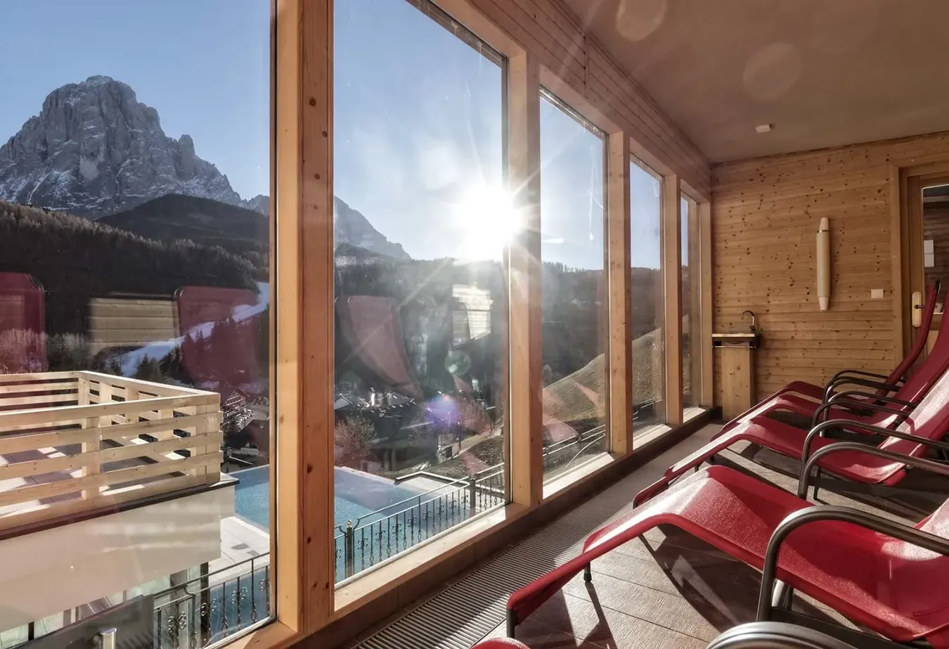 Modernes Chalet-Innenraum mit großen Fenstern, die Bergblick bieten, Boden mit Feinsteinzeugfliesen für eine gemütliche Atmosphäre.