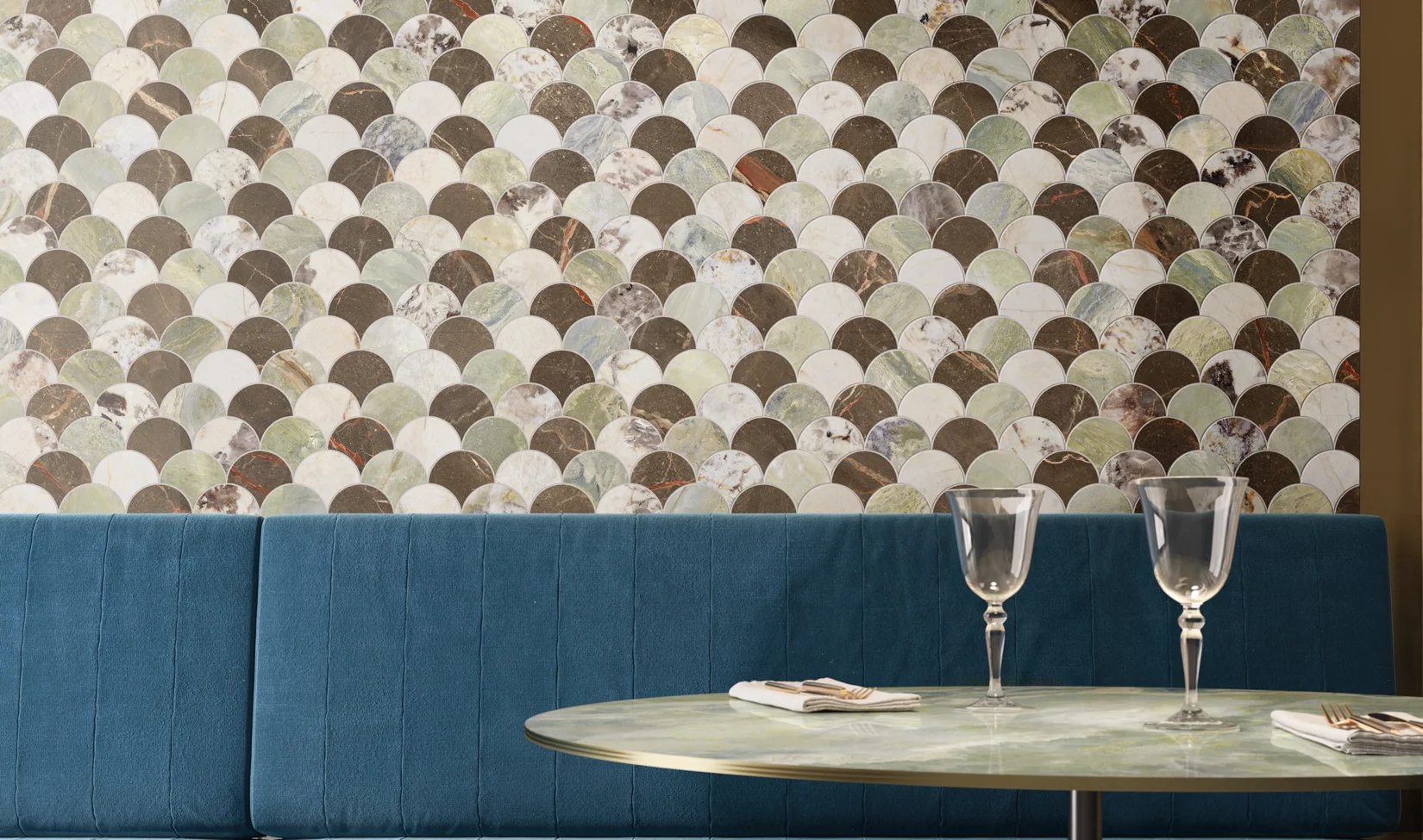 Parete moderna con mosaico 9cento palm mix, piastrelle rotonde multicolore, in contrasto con la panchina blu di una sala da pranzo contemporanea.